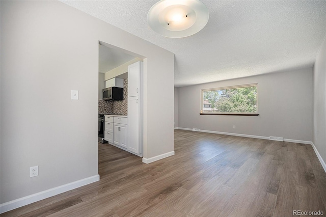 8346 W Woodard Dr, Lakewood, CO 80227 - spare room featuring wood finished floors, a textured ceiling, and baseboards