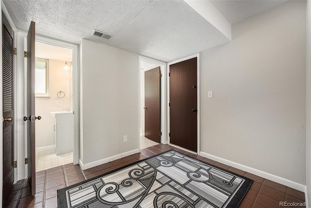 8346 W Woodard Dr, Lakewood, CO 80227 - foyer featuring dark tile patterned floors, a textured ceiling, and baseboards