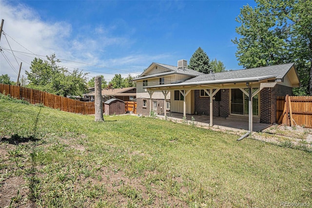 8346 W Woodard Dr, Lakewood, CO 80227 - back of house featuring a patio, brick siding, a shingled roof, and a storage shed