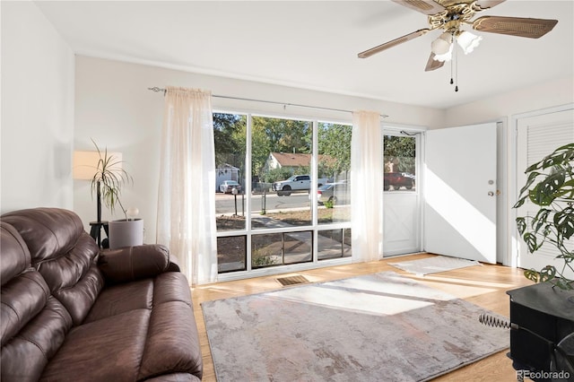 living room with light hardwood / wood-style flooring and ceiling fan