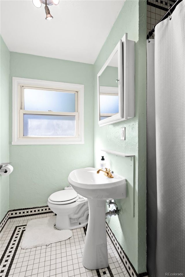 bathroom with tile patterned flooring, curtained shower, and toilet