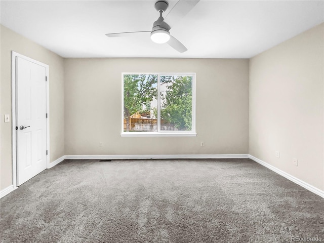 unfurnished room with ceiling fan and carpet