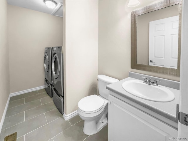 bathroom with vanity, washer and clothes dryer, tile patterned floors, and toilet