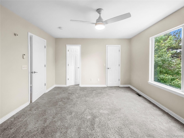 carpeted spare room with ceiling fan