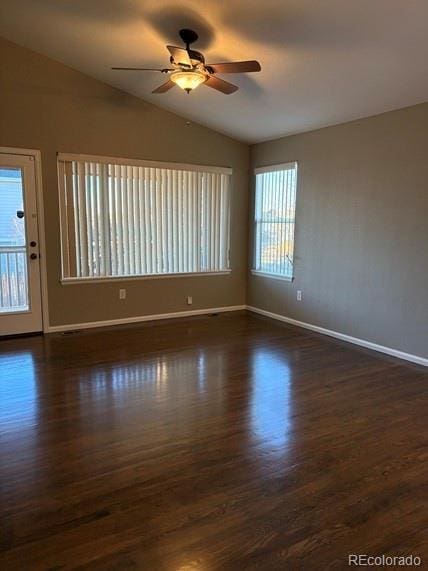 unfurnished room with dark wood-style floors, vaulted ceiling, baseboards, and ceiling fan