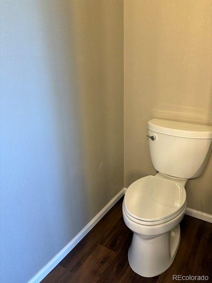 bathroom featuring toilet, baseboards, and wood finished floors