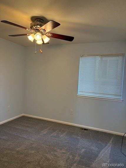 empty room with carpet floors, visible vents, and baseboards