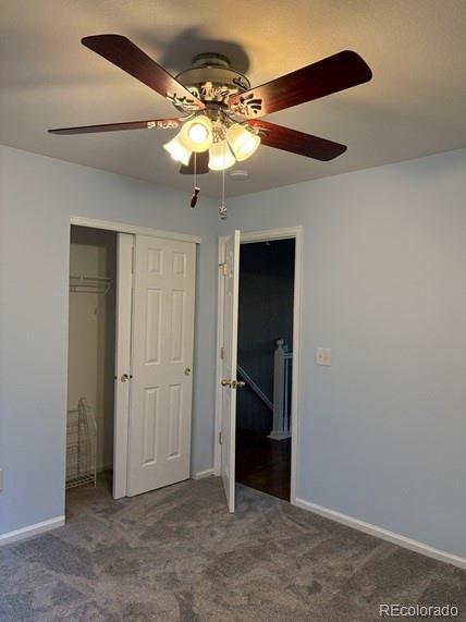 unfurnished bedroom featuring a ceiling fan, a closet, carpet flooring, and baseboards