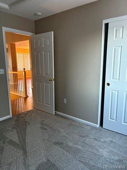 carpeted spare room featuring baseboards