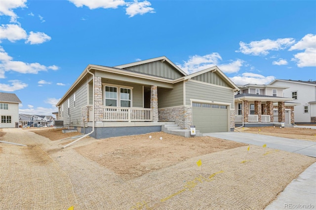 20665 E 57th Dr, Aurora, CO 80019 - view of front of property featuring a porch, board and batten siding, stone siding, driveway, and a garage