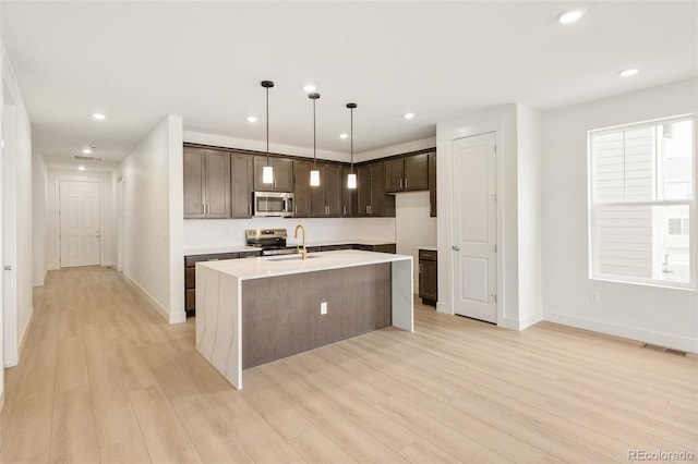 20665 E 57th Dr, Aurora, CO 80019 - kitchen featuring appliances with stainless steel finishes, dark brown cabinetry, light countertops, light wood-style flooring, and recessed lighting