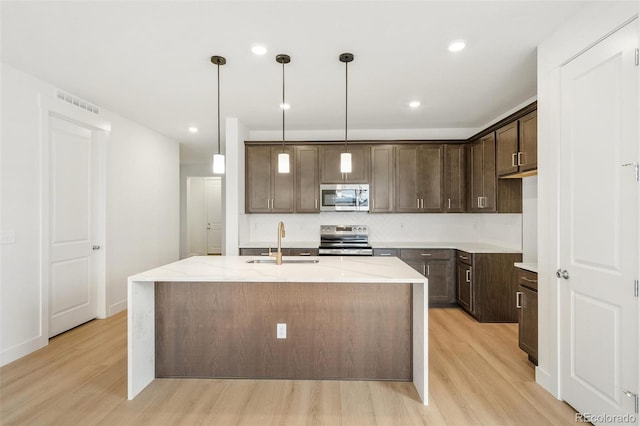 20665 E 57th Dr, Aurora, CO 80019 - kitchen featuring appliances with stainless steel finishes, a sink, light wood-type flooring, dark brown cabinets, and recessed lighting