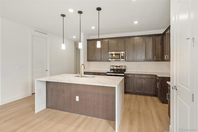 20665 E 57th Dr, Aurora, CO 80019 - kitchen featuring stainless steel appliances, a sink, light wood-style flooring, dark brown cabinetry, and recessed lighting