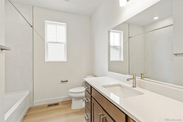 20665 E 57th Dr, Aurora, CO 80019 - full bath with wood finished floors, toilet, vanity, baseboards, and shower / washtub combination