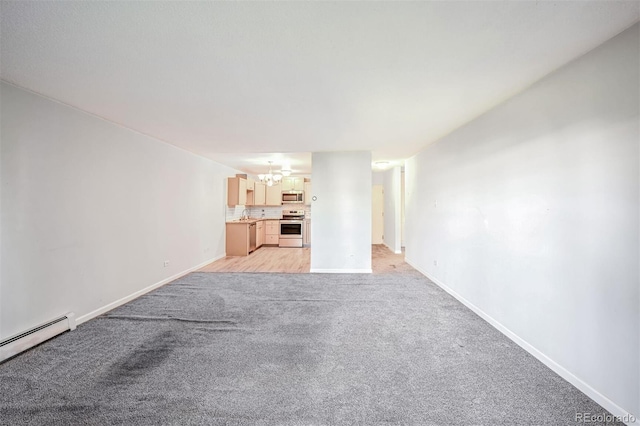 unfurnished living room with a baseboard heating unit, a notable chandelier, and light colored carpet