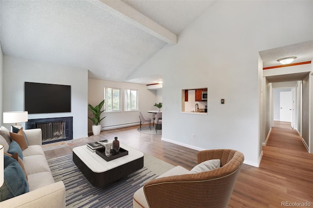 living room featuring hardwood / wood-style floors, baseboard heating, and a textured ceiling