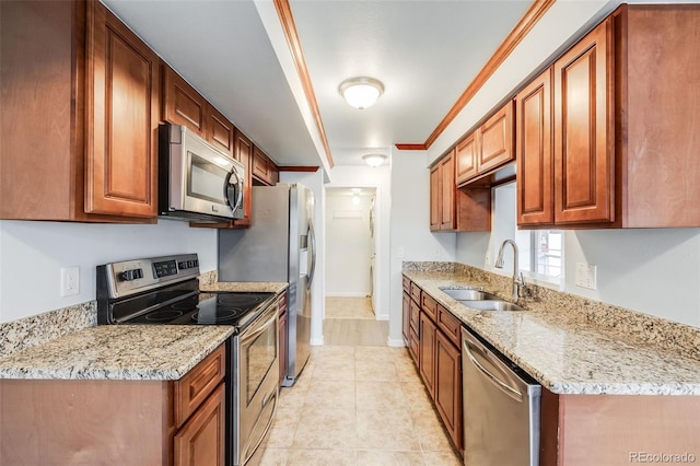 kitchen with light tile patterned floors, light stone countertops, a sink, ornamental molding, and stainless steel appliances