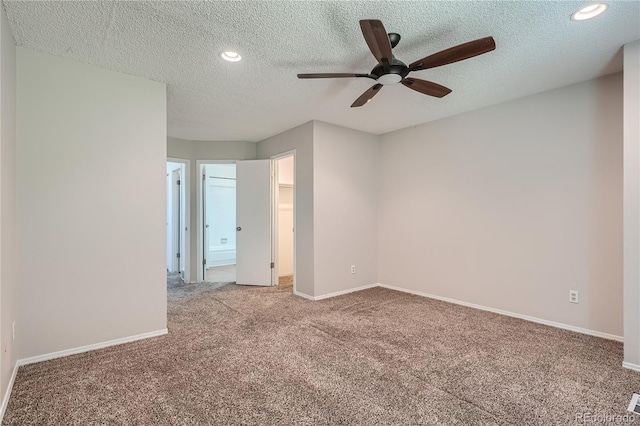 spare room with a textured ceiling, ceiling fan, and light colored carpet