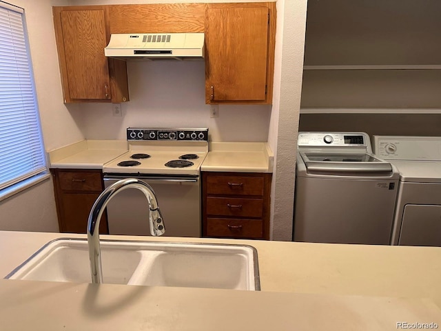 kitchen with electric range, brown cabinetry, range hood, light countertops, and a sink