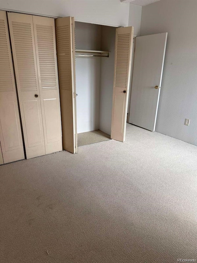 unfurnished bedroom featuring light carpet