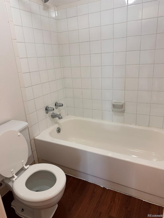 full bath featuring toilet, wood finished floors, and shower / bathtub combination