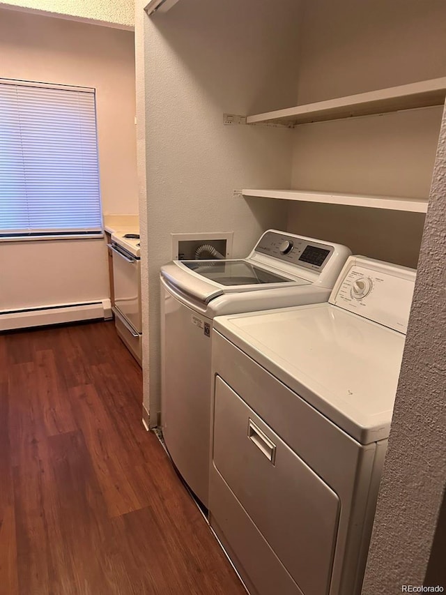 clothes washing area with a baseboard heating unit, laundry area, washer and clothes dryer, and dark wood finished floors