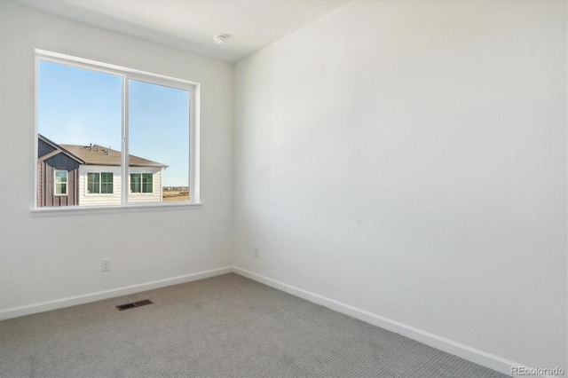 spare room featuring plenty of natural light and carpet