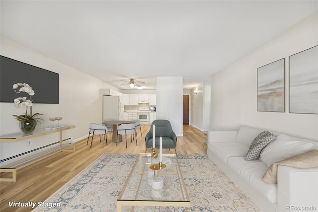 7020 E Girard Ave Unit 109, Denver, CO 80224 - living area featuring a baseboard heating unit, light wood-type flooring, and a ceiling fan