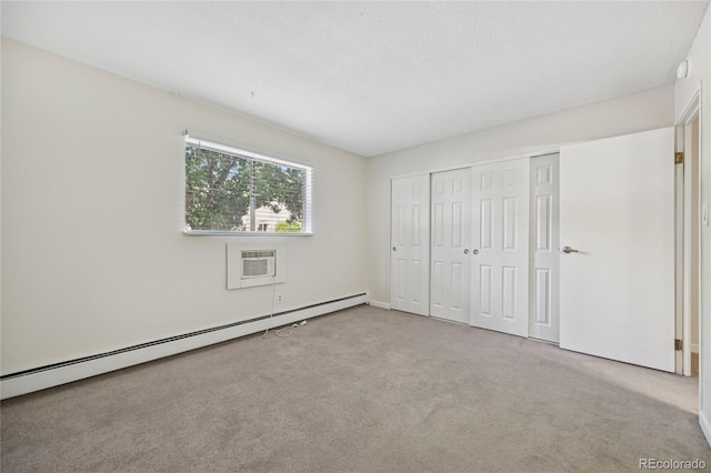 7020 E Girard Ave Unit 109, Denver, CO 80224 - unfurnished bedroom with a wall mounted AC, carpet flooring, a baseboard radiator, and a closet
