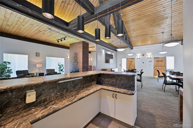 7020 E Girard Ave Unit 109, Denver, CO 80224 - kitchen with open floor plan, white cabinets, wooden ceiling, hanging light fixtures, and carpet
