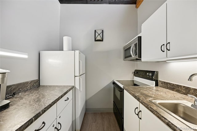 7020 E Girard Ave Unit 109, Denver, CO 80224 - kitchen featuring electric range, stainless steel microwave, freestanding refrigerator, dark wood-type flooring, and white cabinetry