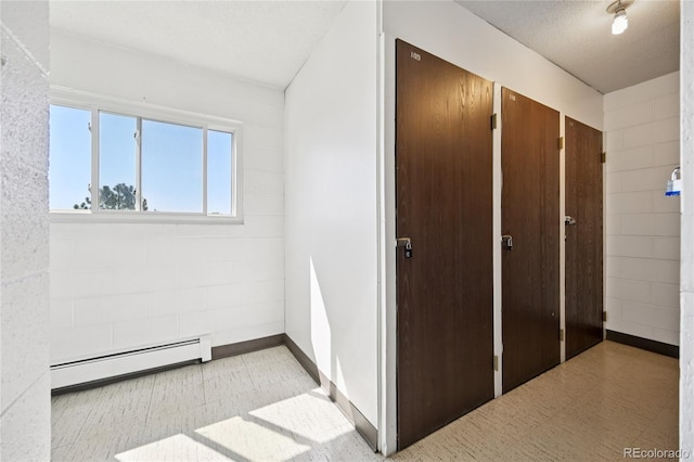 7020 E Girard Ave Unit 109, Denver, CO 80224 - hallway with a baseboard radiator, tile patterned floors, and a textured ceiling