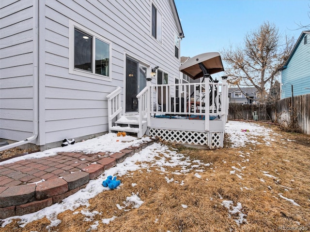 view of snowy exterior featuring a deck