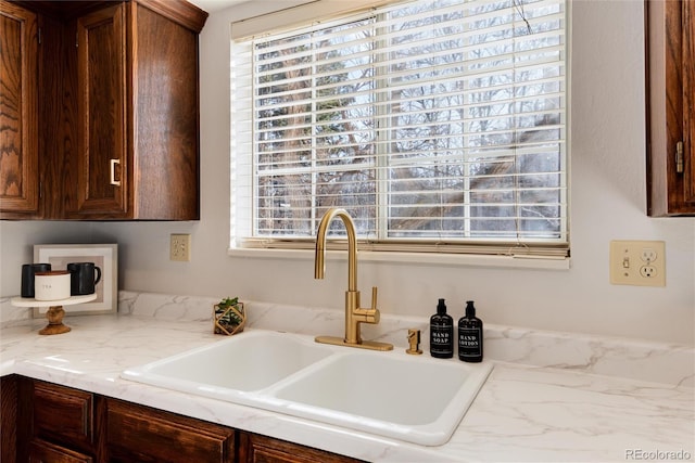 kitchen with dark brown cabinetry, a healthy amount of sunlight, and a sink