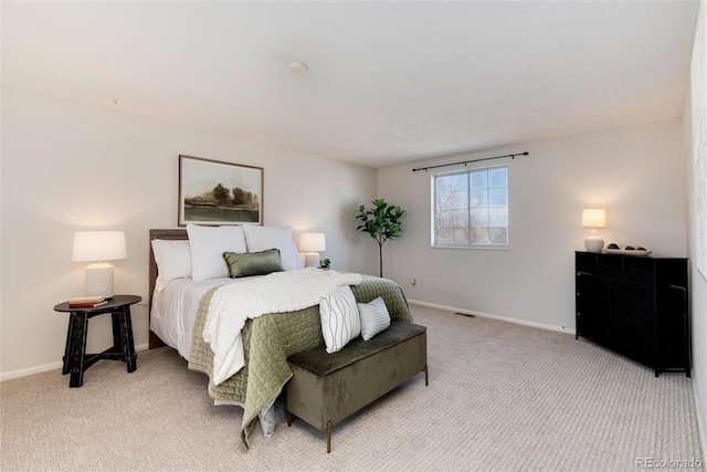 bedroom with baseboards and light carpet