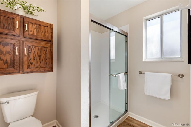 full bath featuring a stall shower, toilet, and baseboards