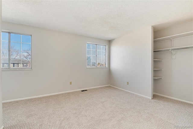 unfurnished bedroom with visible vents, carpet floors, and baseboards