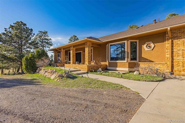 17675 State Highway 83, Colorado Springs, CO 80908 - view of front of property with brick siding, covered porch, and stucco siding