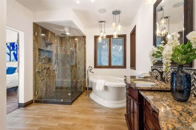 bathroom with shower with separate bathtub, wood-type flooring, and vanity