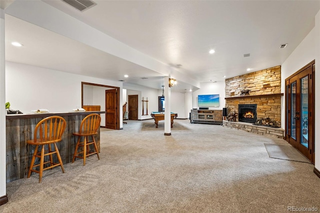 living room with bar, a fireplace, and carpet