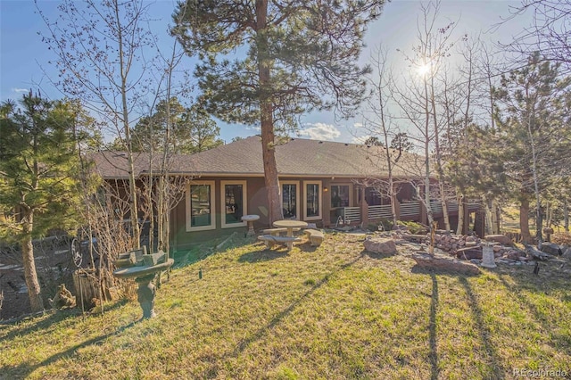 rear view of house featuring french doors and a lawn