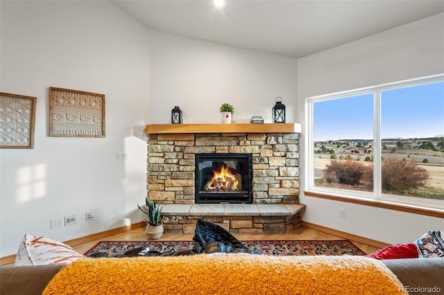 living room featuring a fireplace, wood-type flooring, and a wealth of natural light