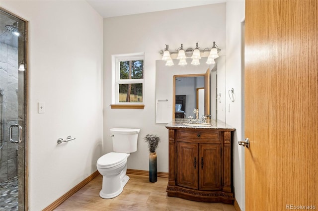 bathroom with wood-type flooring, toilet, vanity, and an enclosed shower