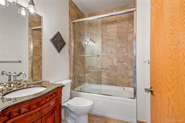 full bathroom with bath / shower combo with glass door, toilet, and vanity