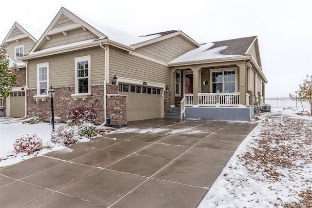 view of front of home featuring a garage, central air condition unit, and a porch