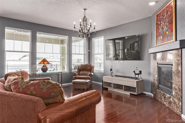 interior space with dark wood-type flooring, a chandelier, plenty of natural light, and a textured ceiling