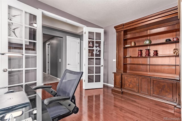 office space with french doors, hardwood / wood-style floors, a textured ceiling, and vaulted ceiling