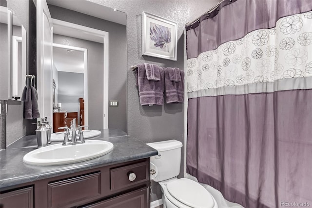 bathroom with toilet, vanity, and walk in shower