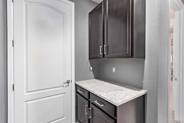 kitchen with dark brown cabinets and light stone countertops