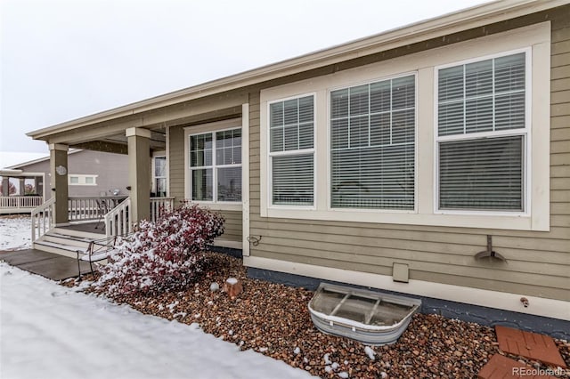 view of snow covered exterior featuring a wooden deck